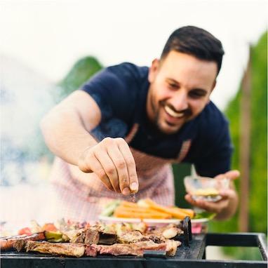 homme faisant cuire viande au barbecue